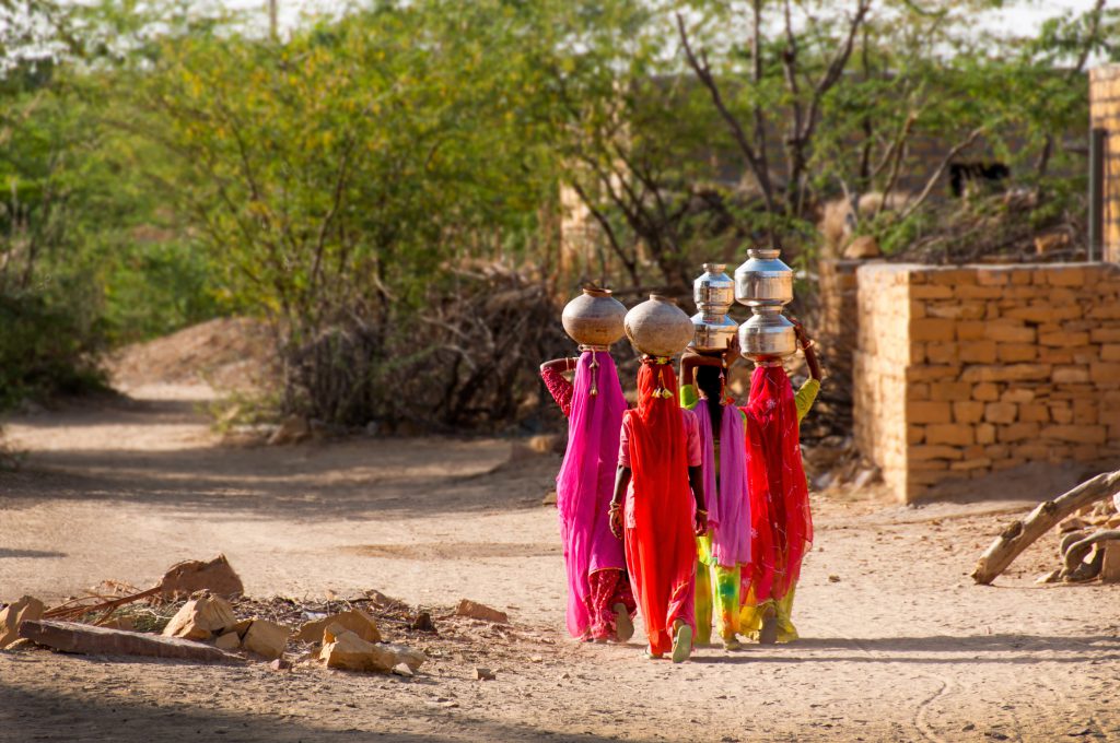 Water carries heading home, desert village near Jailsalmer, Rajasthan, India.