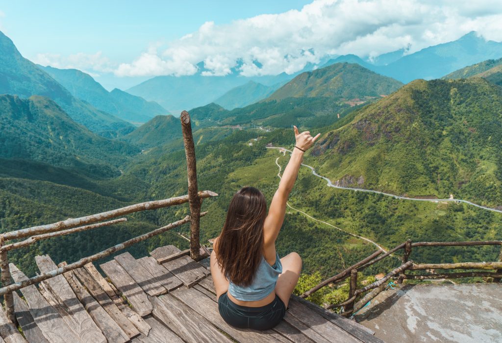 Image of woman perched at a scenic lookout overlooking Sapa in Vietnam.